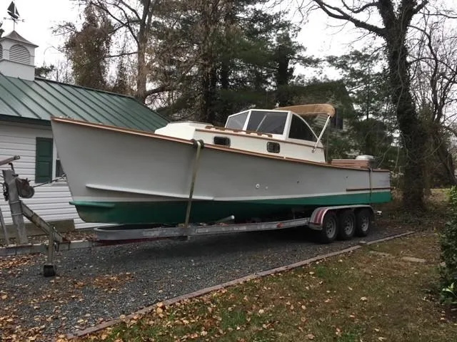 Slide: The Image of Custom Vansant 30 boat from 1987 on a trailer in a wooded area. - 4