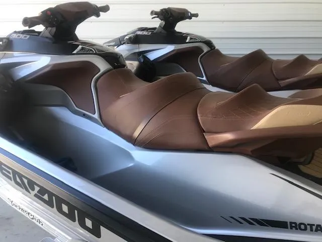 Slide: The Image of 2019 Sea-Doo RXT jet skis with brown seats in storage. - 3
