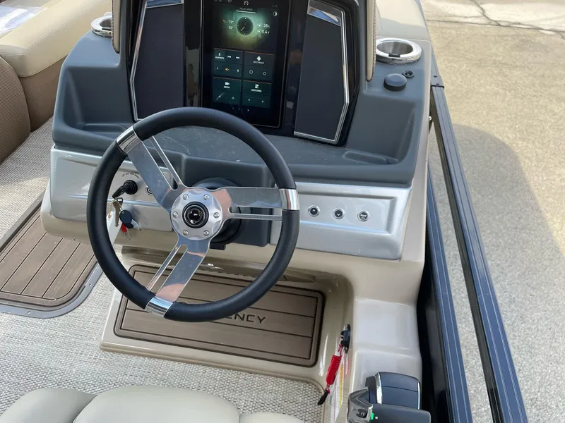 Slide: The Image of 2023 Regency 230 LE3 boat dashboard with steering wheel and touchscreen controls. - 10