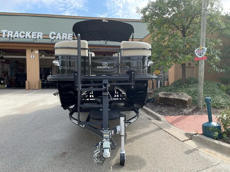 Slide: The Image of 2023 Regency 230 LE3 pontoon boat on trailer outside Tracker Garage. - 12
