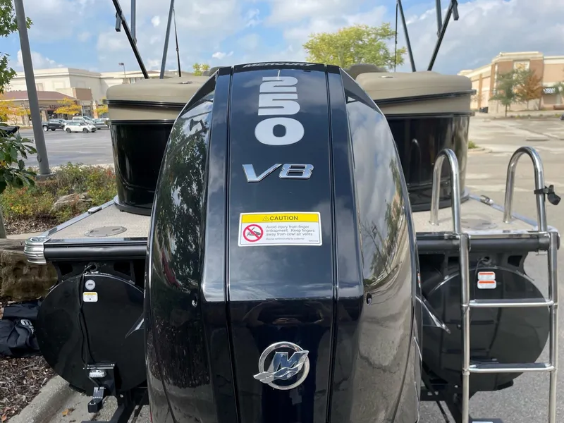 Slide: The Image of 2023 Regency 230 LE3 boat with a 250 V8 engine in a parking lot. - 14