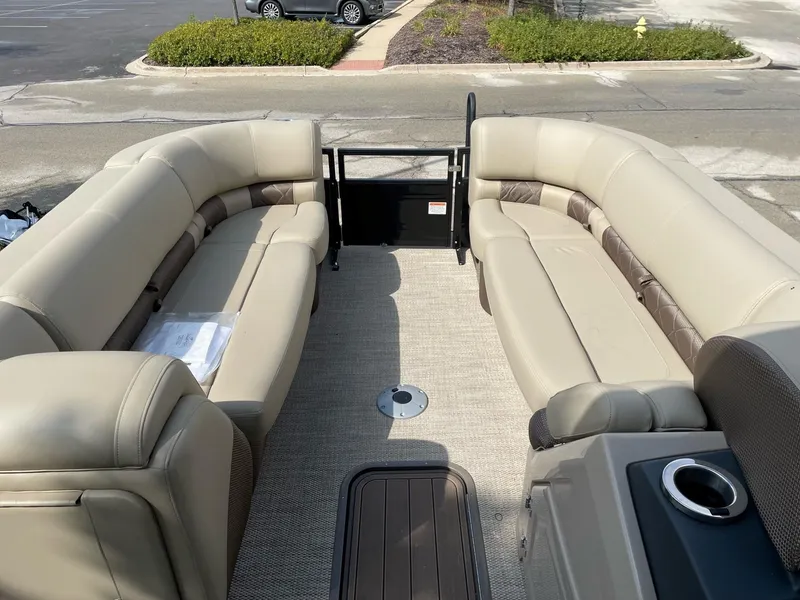 Slide: The Image of 2023 Regency 230 LE3 pontoon boat interior with beige seating and cup holders. - 4