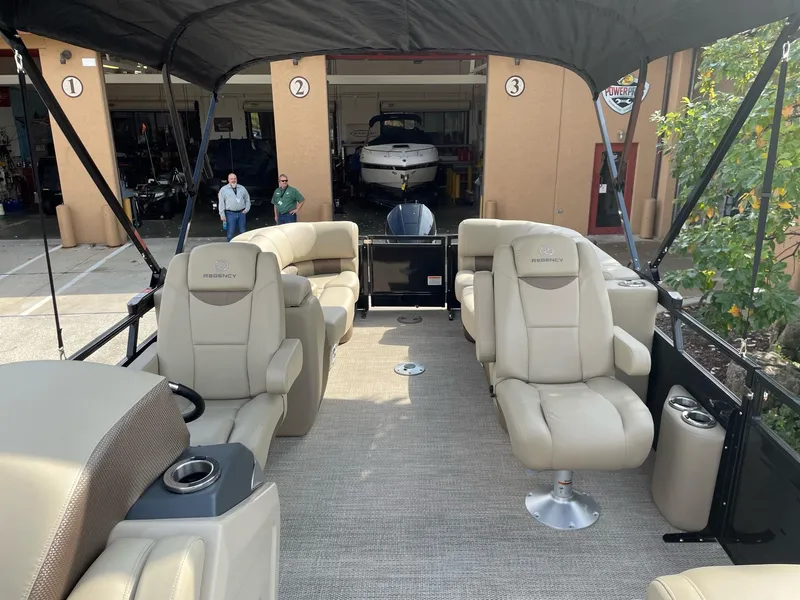 Slide: The Image of 2023 Regency 230 LE3 pontoon boat with beige seating and canopy. - 5