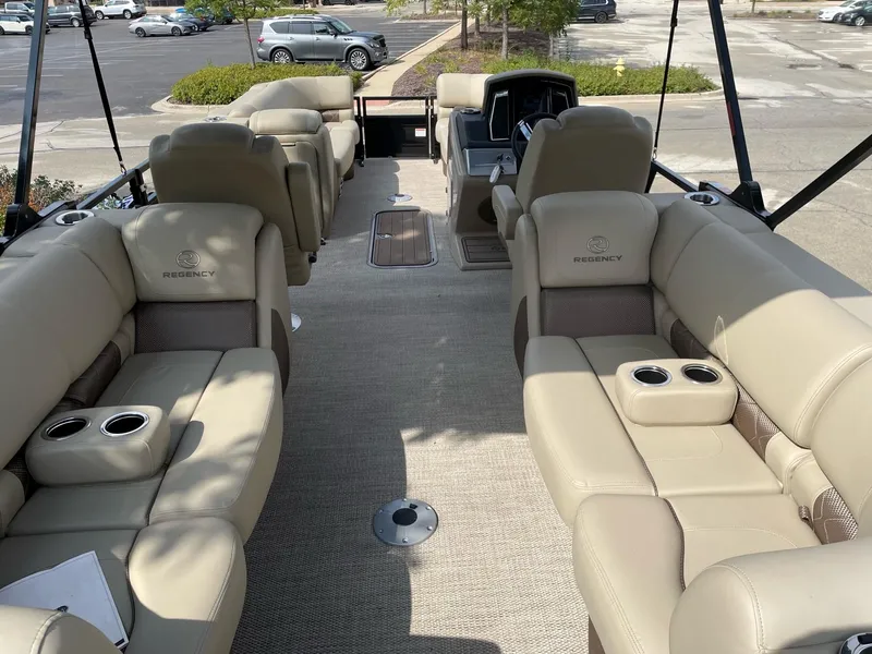 Slide: The Image of 2023 Regency 230 LE3 boat interior with beige leather seating and cup holders. - 7