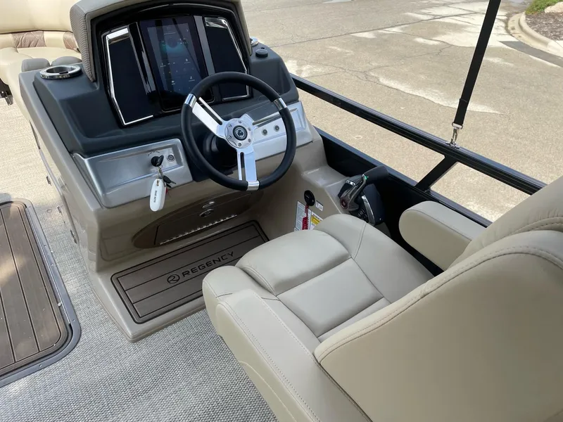 Slide: The Image of 2023 Regency 230 LE3 boat cockpit with steering wheel and control panel. - 8