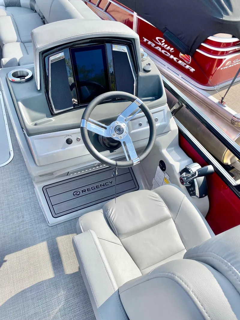 Slide: The Image of 2023 Regency 250 LE3 Sport boat interior with steering wheel and dashboard. - 4
