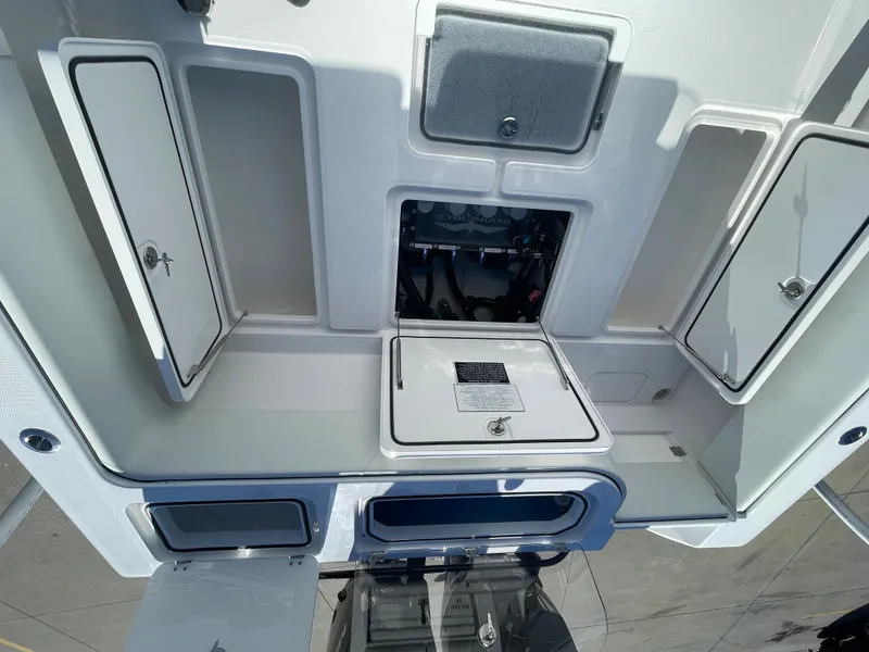 Slide: The Image of 2024 Invincible 33 Open Fisherman storage compartments and engine access. - 19