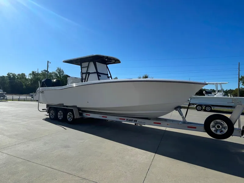 Slide: The Image of 2024 Invincible 33 Open Fisherman boat on a trailer in a sunny outdoor setting. - 5