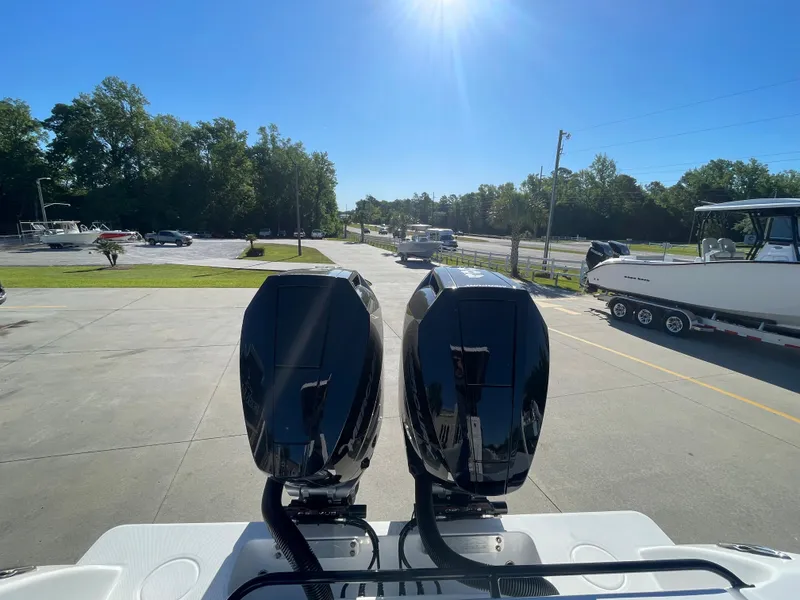 Slide: The Image of 2024 Invincible 33 Open Fisherman with dual outboard engines in a sunny parking lot. - 7