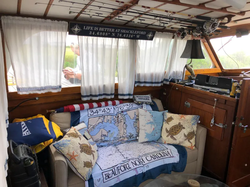 Slide: The Image of 1963 Egg Harbor Convertible Cruiser interior with nautical decor and cozy seating area. - 13