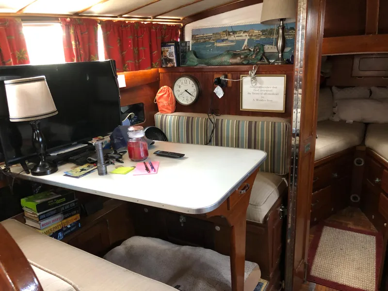 Slide: The Image of 1963 Egg Harbor Convertible Cruiser interior with table, striped seating, and nautical decor. - 24