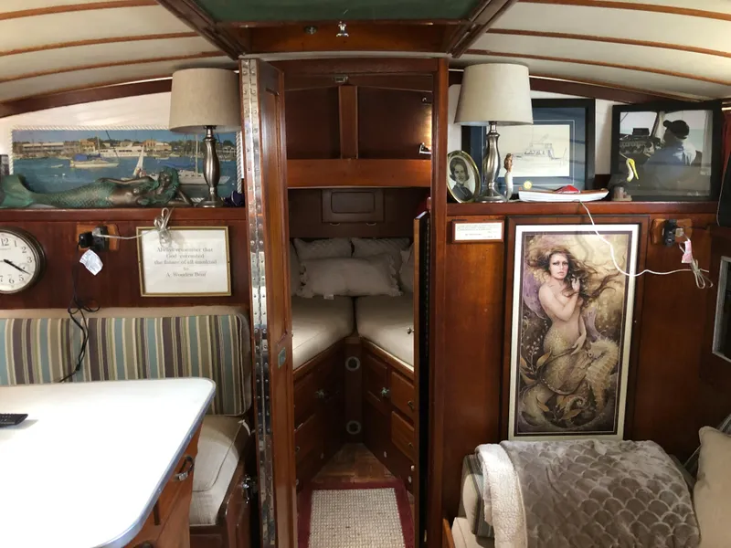 Slide: The Image of 1963 Egg Harbor Convertible Cruiser interior with cozy cabin, nautical decor, and vintage artwork. - 25