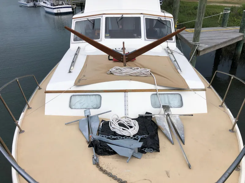 Slide: The Image of 1963 Egg Harbor Convertible Cruiser with anchors and ropes on deck, docked by the water. - 7