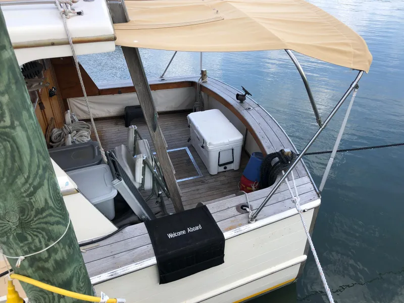 Slide: The Image of 1963 Egg Harbor Convertible Cruiser with canopy, docked, featuring deck seating and cooler. - 9