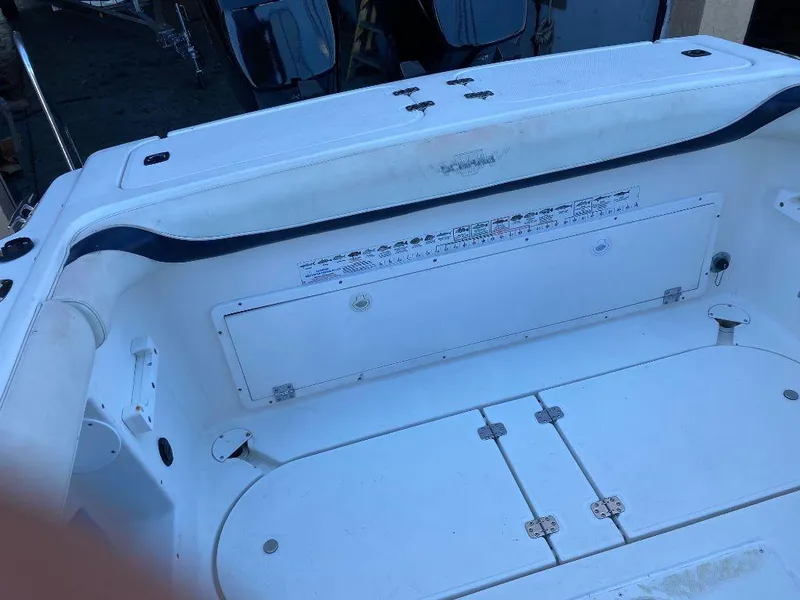 Slide: The Image of 1999 Wellcraft 302 Sport boat interior, white seating and storage compartments. - 12