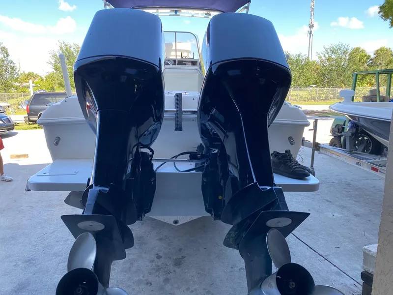 Slide: The Image of 1999 Wellcraft 302 Sport boat with dual outboard motors, docked on a sunny day. - 14