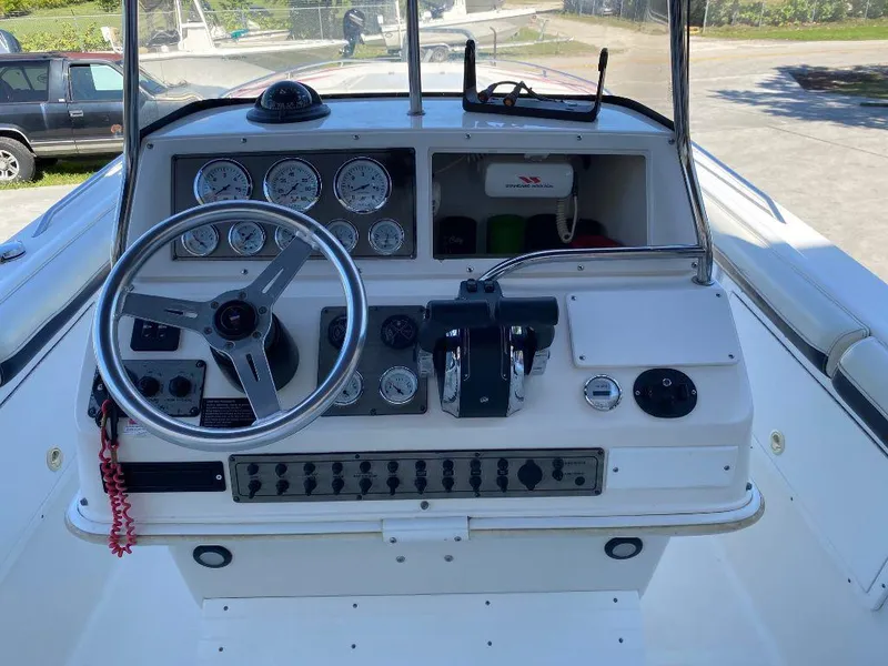 Slide: The Image of 1999 Wellcraft 302 Sport boat dashboard with steering wheel and control panel. - 9