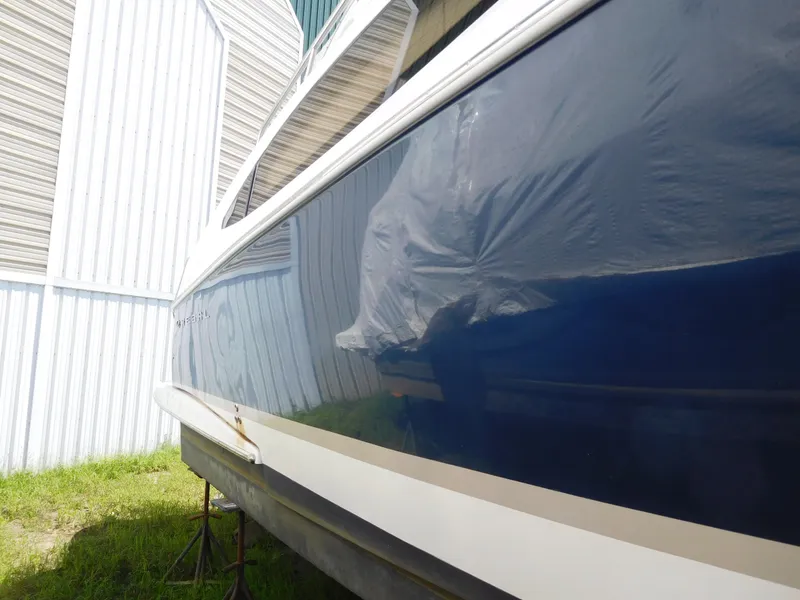 Slide: The Image of 2007 Regal 4080 Sportyacht side view, blue hull, stored outdoors. - 13