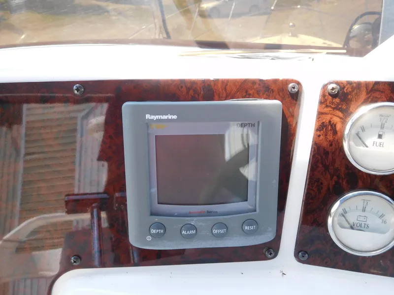 Slide: The Image of Raymarine depth gauge on 2007 Regal 4080 Sportyacht dashboard with wood paneling. - 35