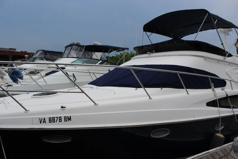 Slide: The Image of 2007 Regal 4080 Sportyacht docked with other boats, featuring sleek design and dark canopy. - 4