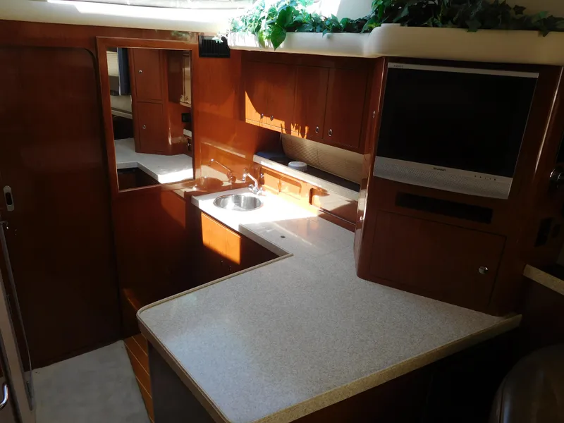 Slide: The Image of 2007 Regal 4080 Sportyacht interior with kitchenette, sink, and TV. - 43