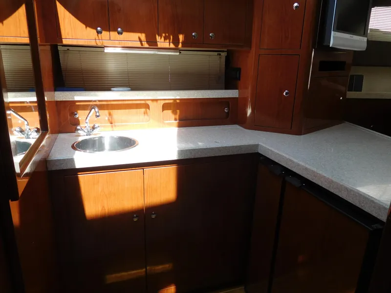 Slide: The Image of 2007 Regal 4080 Sportyacht kitchen with wood cabinets and countertop. - 46