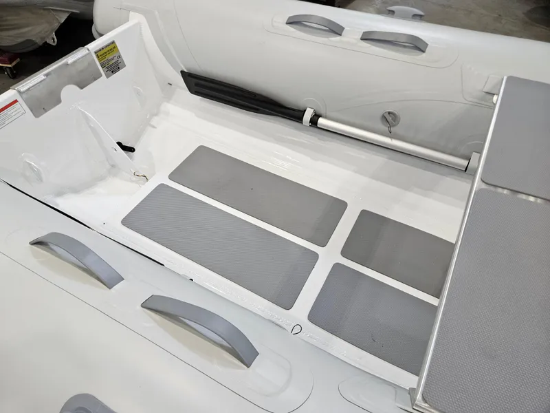 Slide: The Image of 2023 AB Inflatables 10 AL boat interior with seating and oar. - 6