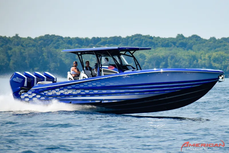 Slide: The Image of 2026 Nor-Tech 390 Sport boat cruising on water with passengers, featuring vibrant blue design. - 2