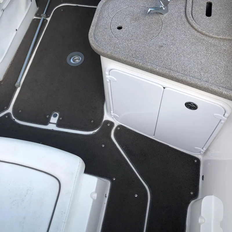 Slide: The Image of 2008 Rinker 230 Captiva boat interior with storage compartment and non-slip flooring. - 3