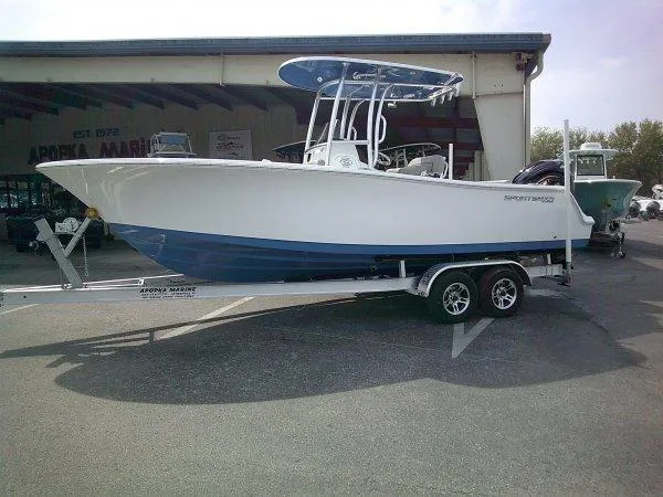 Slide: The Image of 2023 Sportsman 232 Open boat on trailer, parked outside a marine dealership. - 1