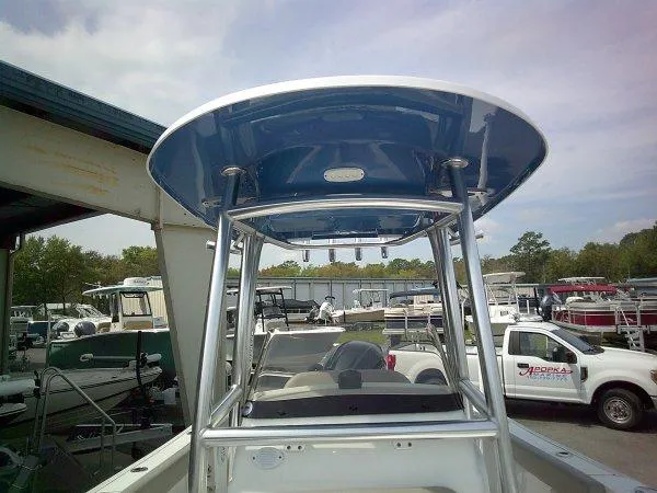 Slide: The Image of 2023 Sportsman 232 Open boat with T-top, parked in a marina. - 2