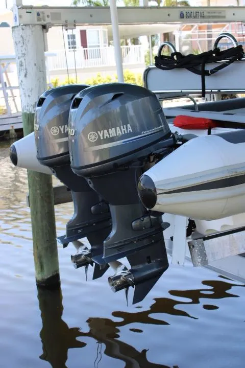 Slide: The Image of Twin Yamaha outboard motors on a 2021 Ballistic RIB boat docked by the water. - 19