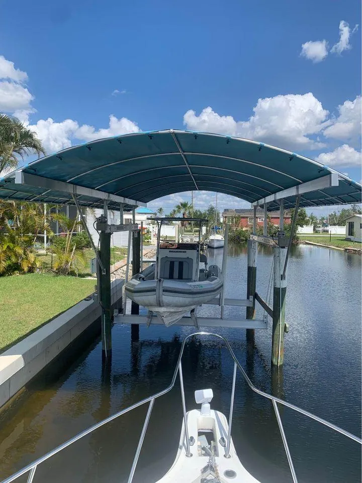 Slide: The Image of 2021 Ballistic RIB boat docked under a canopy on a sunny day. - 2