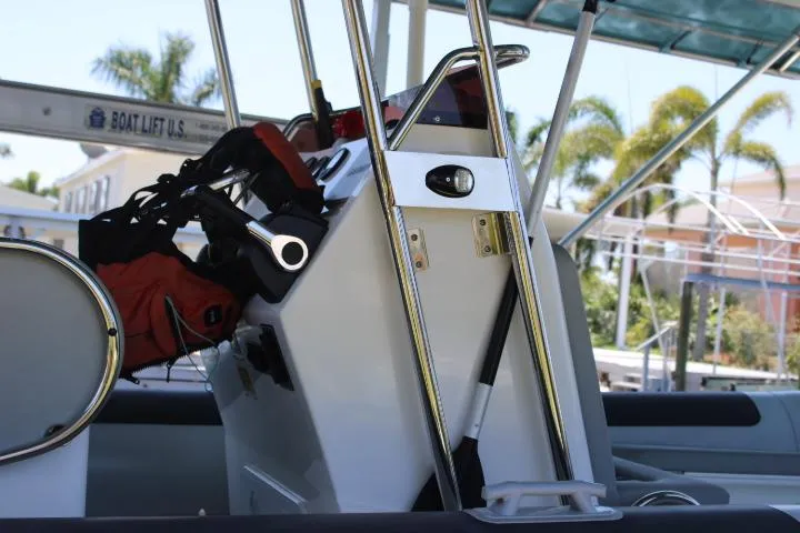 Slide: The Image of 2021 Ballistic RIB boat console with safety equipment and palm trees in the background. - 23