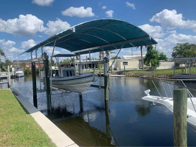 Slide: The Image of 2021 Ballistic RIB boat on a covered lift at a marina. - 4