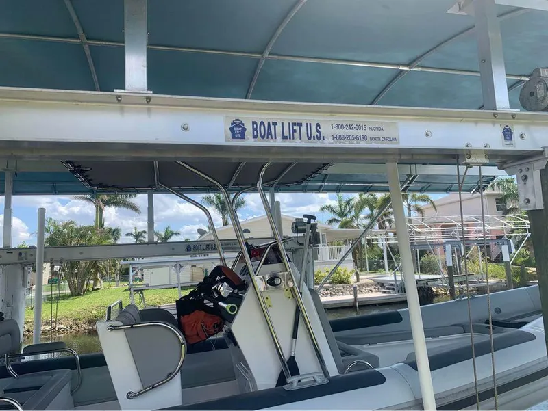 Slide: The Image of Ballistic RIB 2021 on Boat Lift U.S. dock, waterfront view. - 6