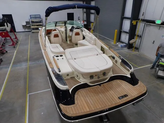 Slide: The Image of 2023 Chris-Craft Launch 25 GT boat in a warehouse, showcasing luxury seating and teak flooring. - 3