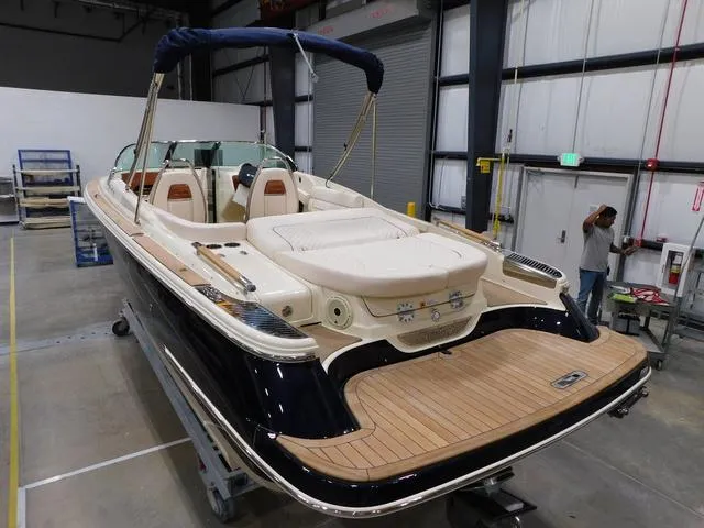 Slide: The Image of 2023 Chris-Craft Launch 25 GT boat in a warehouse, rear view. - 5