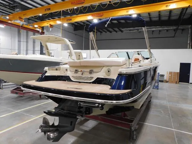 Slide: The Image of 2023 Chris-Craft Launch 25 GT boat in a showroom, rear view. - 6