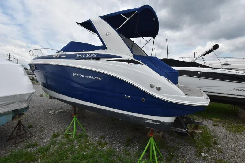 Slide: The Image of 2021 Crownline 264 CR boat with blue and white exterior on stands. - 13