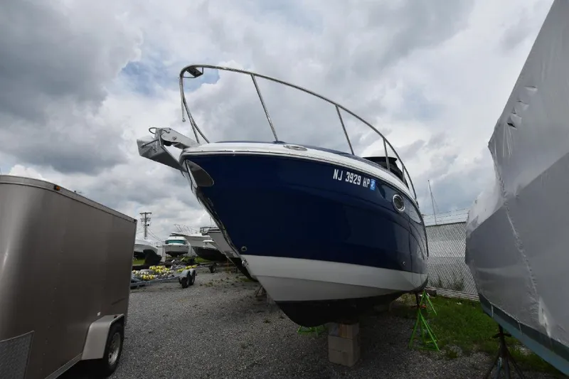 Slide: The Image of 2021 Crownline 264 CR boat on dry dock, blue hull, overcast sky. - 15