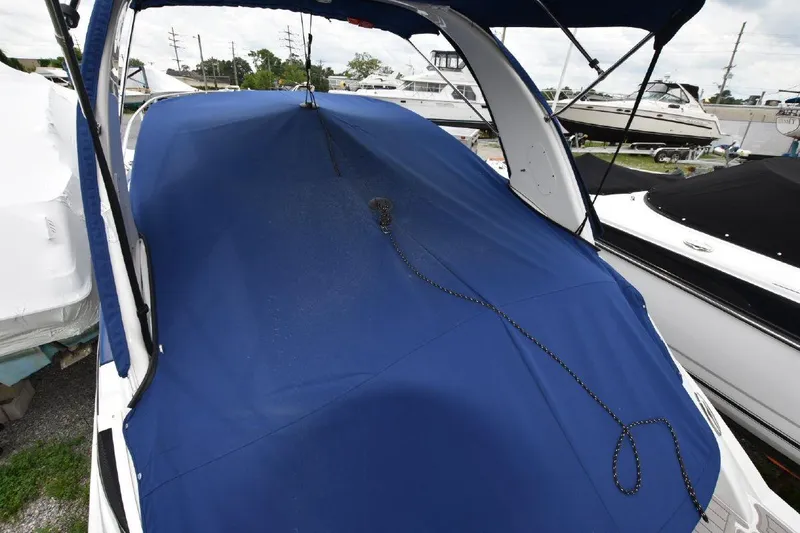 Slide: The Image of 2021 Crownline 264 CR boat with blue cover in marina. - 34