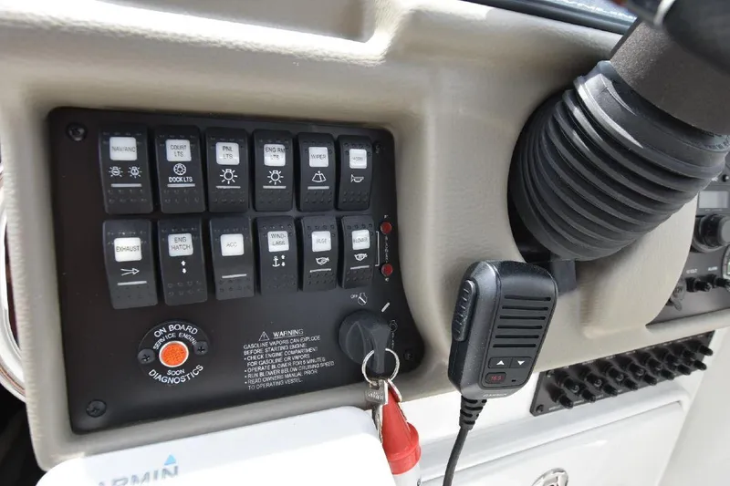 Slide: The Image of Control panel of a 2021 Crownline 264 CR boat with various switches and a microphone. - 39