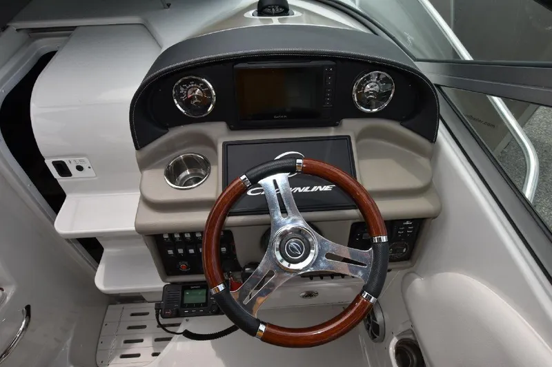 Slide: The Image of 2021 Crownline 264 CR boat dashboard with wood-trimmed steering wheel and modern controls. - 41