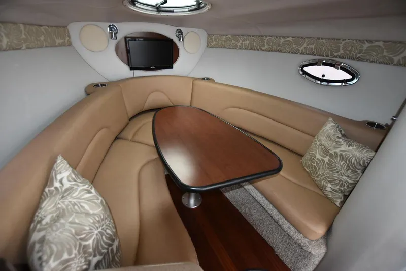 Slide: The Image of 2021 Crownline 264 CR cabin interior with leather seating and wooden table. - 6