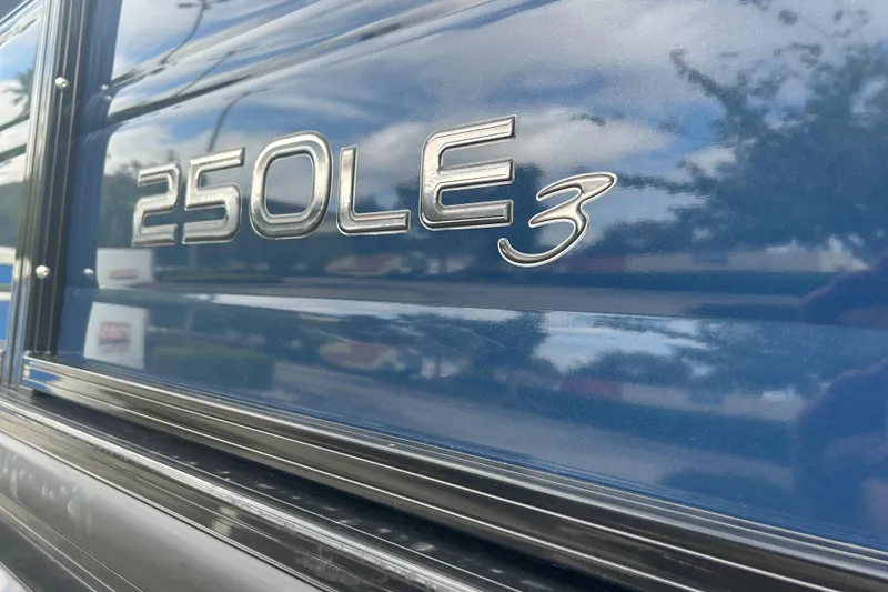 Slide: The Image of Close-up of 2023 Regency 250 LE3 model emblem on a blue surface. - 16