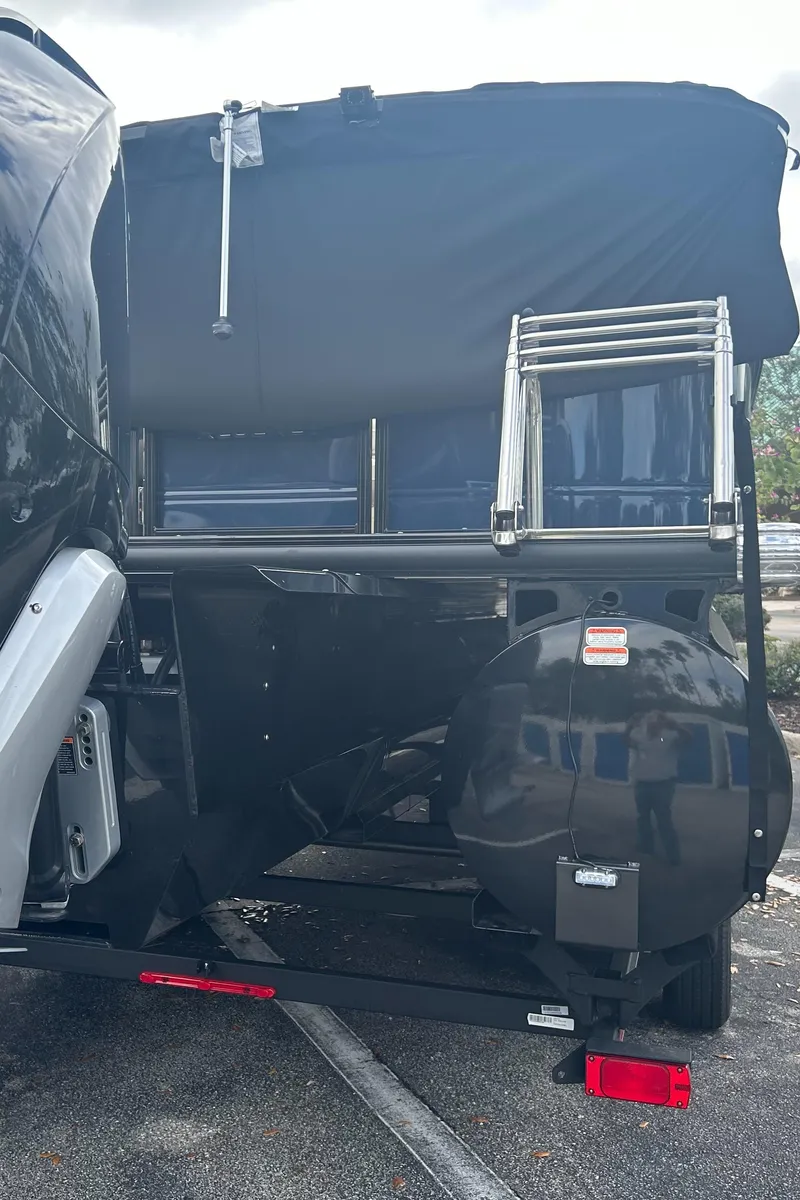 Slide: The Image of 2023 Regency 250 LE3 boat rear view with ladder and cover. - 2