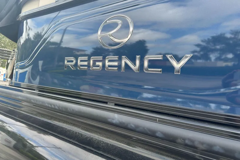 Slide: The Image of 2023 Regency 250 LE3 boat exterior with logo and reflective surface. - 3