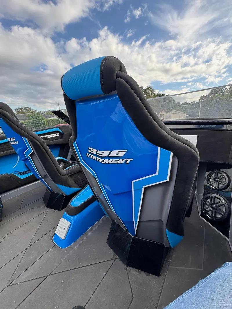 Slide: The Image of Blue and black seats in a 2026 Statement 396 Cat boat under a cloudy sky. - 16