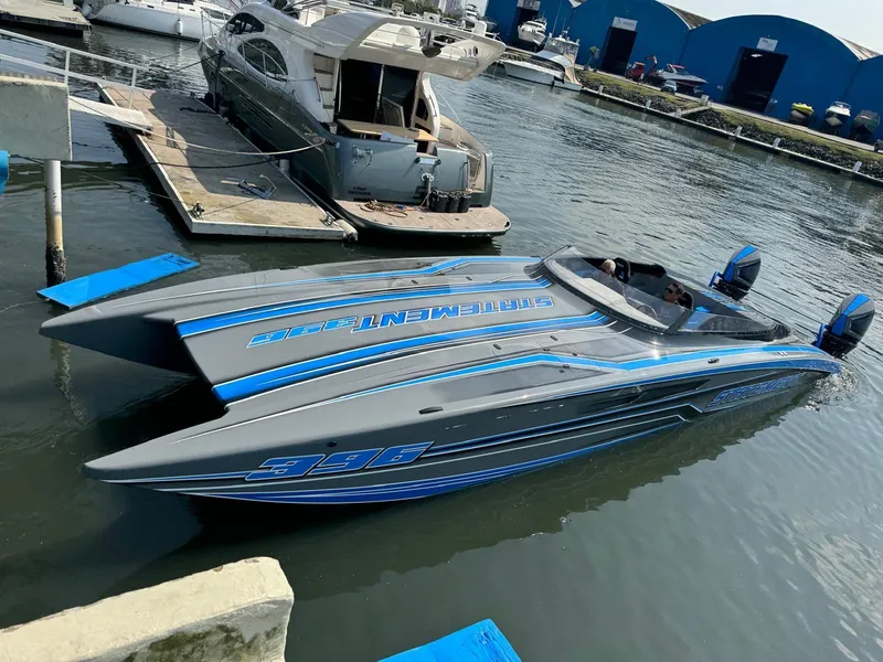 Slide: The Image of 2025 Statement 396 Cat powerboat docked in marina, sleek design with blue accents. - 7